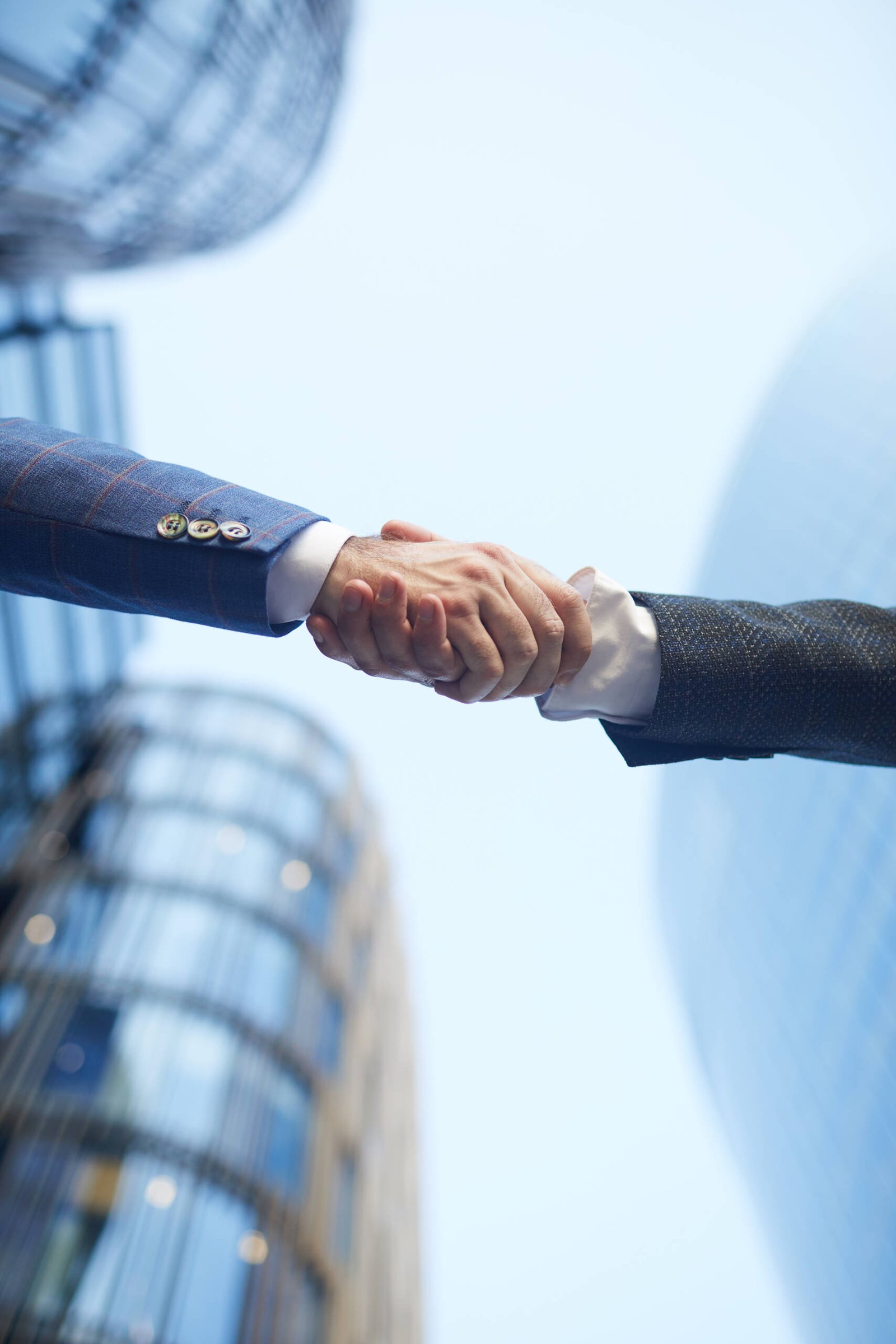 Low angle view of business people shaking hands to each other against the office building outdoors
